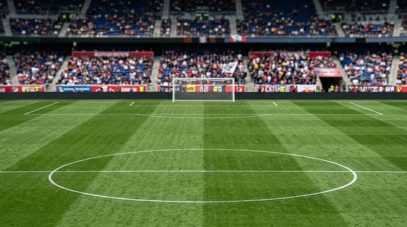 Vista central de un campo de fútbol profesional con las dos porterías visibles desde el centro del terreno de juego